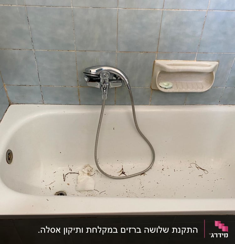 אמבטיה עם לכלוך, ברז ומקלחת יד
